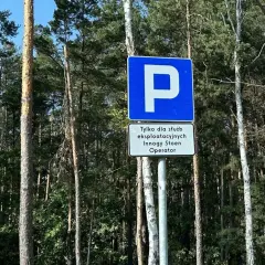 Znak D18 informuje o parkingu tylko dla służb eksploatacyjnych Innogy Stoen Operator. Otoczenie to gęsty las.