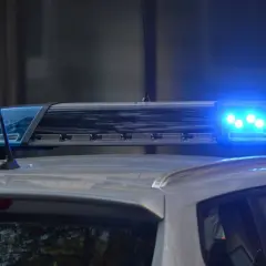 Niebieskie światła pojazdu uprzywilejowanego migają na dachu radiowozu.