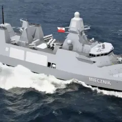 Nowoczesna fregata ORP Miecznik, część polskiej marynarki wojennej, z helikopterem na pokładzie, pruje fale.