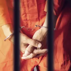 Ręce w kajdankach, w pomarańczowym kombinezonie, za kratami. Czekając na decyzję, po jakim czasie policja doprowadza do zk.