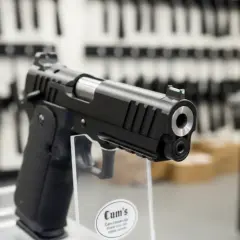 Czarny pistolet na wystawie. Zastanawiasz się, ile kosztuje pozwolenie na broń?