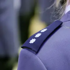 Trzy białe gwiazdki na granatowym naramienniku munduru policyjnego. To jeden ze sposobów, by poznać, jakie są stopnie w policji.
