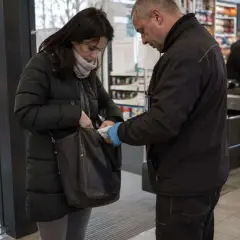 Ochroniarz w sklepie sprawdza zawartość torby kobiety. W tle widać kasy i półki z produktami. Numer 278 kk.