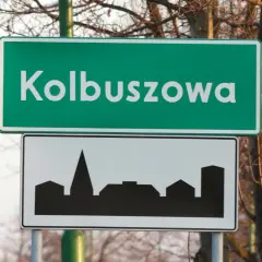 Znak drogowy Kolbuszowa z sylwetką zabudowy miejskiej. Wjazd do miasta.