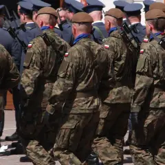 Żołnierze w mundurach polowych, z karabinami, maszerują w szyku. Widać polskie flagi na rękawach. To wyższy stopień podoficerski w marynarce wojennej.