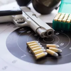 Pistolet, amunicja i tarcza strzelnicza. Wszystko gotowe do treningu, który może być częścią starań o pozwolenie na broń.