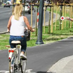 Policjant zatrzymuje kobietę jadącą rowerem po chodniku.
