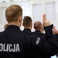 Policjanci w mundurach podnoszą ręce. Zastanawiasz się, ile zarabia pracownik cywilny w policji?