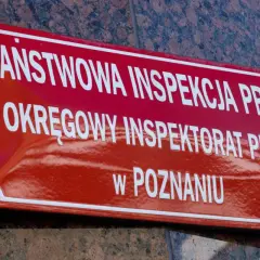 Tablica Państwowej Inspekcji Pracy w Poznaniu. To tutaj nadzór i kontrolę nad przestrzeganiem prawa pracy sprawuje instytucja dbająca o bezpieczeństwo pracowników.