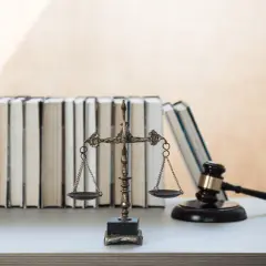 Waga sprawiedliwości, młotek sędziowski i stos książek prawniczych. Symbolika prawa i wymiaru sprawiedliwości, jakby z podręcznika 160 kk.