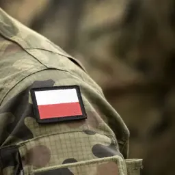 Fragment munduru żołnierza z naszywką z polską flagą. Symbol dumy i służby, odzwierciedlający stopnie w wojsku.