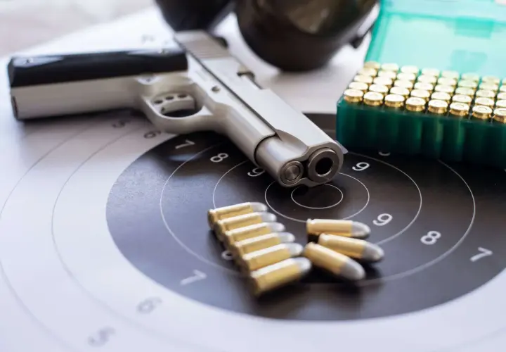 Pistolet, amunicja i tarcza strzelnicza. Wszystko gotowe do treningu, który może być częścią starań o pozwolenie na broń.