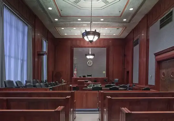 Pusta sala sądowa, gotowa na złożenie **zażalenia**. Drewniane ławy i podwyższenie dla sędziego tworzą uroczystą atmosferę.
