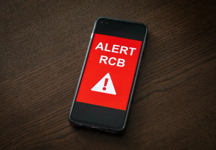 Telefon wyświetla komunikat "ALERT RCB" i symbol ostrzeżenia. To sygnał, że podniesiono stopnie alarmowe.