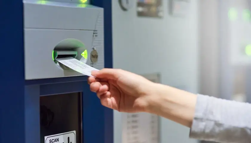 Ręka wkłada paragon do parkometru. Czy to europark mandat czy płacić?