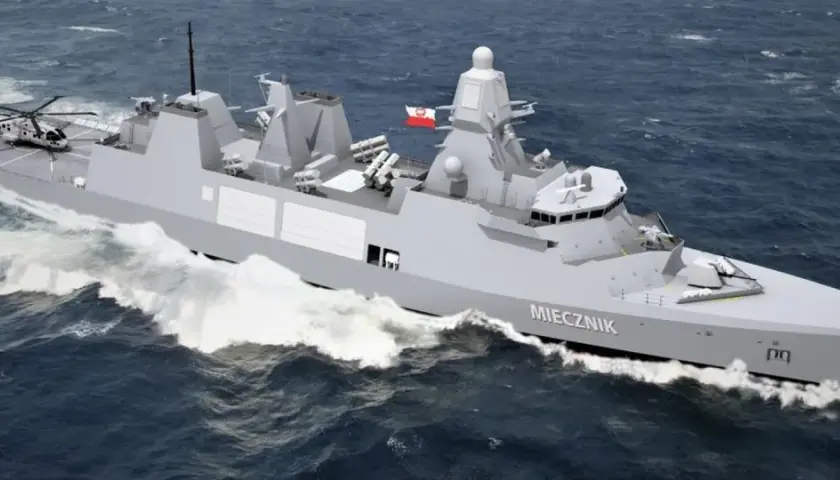 Nowoczesna fregata ORP Miecznik, część polskiej marynarki wojennej, z helikopterem na pokładzie, pruje fale.