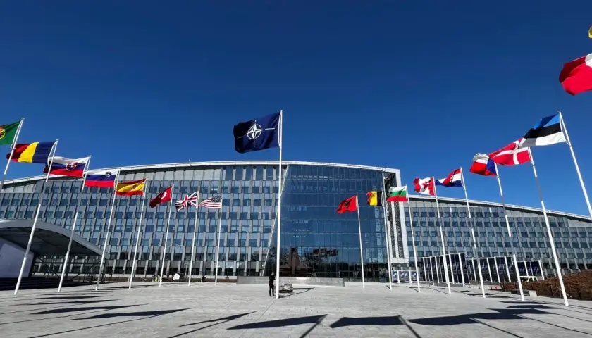 Przed budynkiem NATO, symbolizującym art. 5 traktatu, powiewają flagi państw członkowskich.