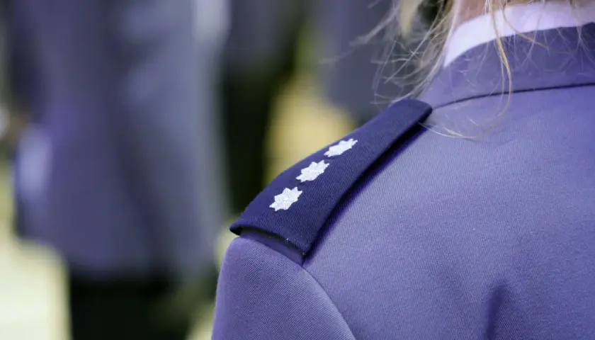 Trzy białe gwiazdki na granatowym naramienniku munduru policyjnego. To jeden ze sposobów, by poznać, jakie są stopnie w policji.