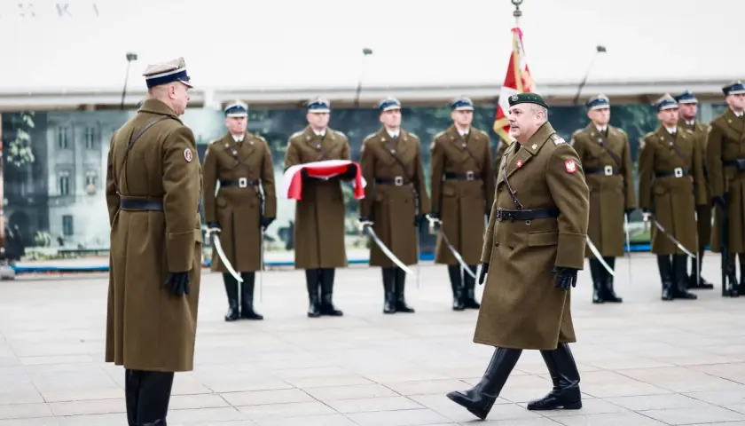 Szef sztabu generalnego w otoczeniu żołnierzy w historycznych mundurach, podczas uroczystości.