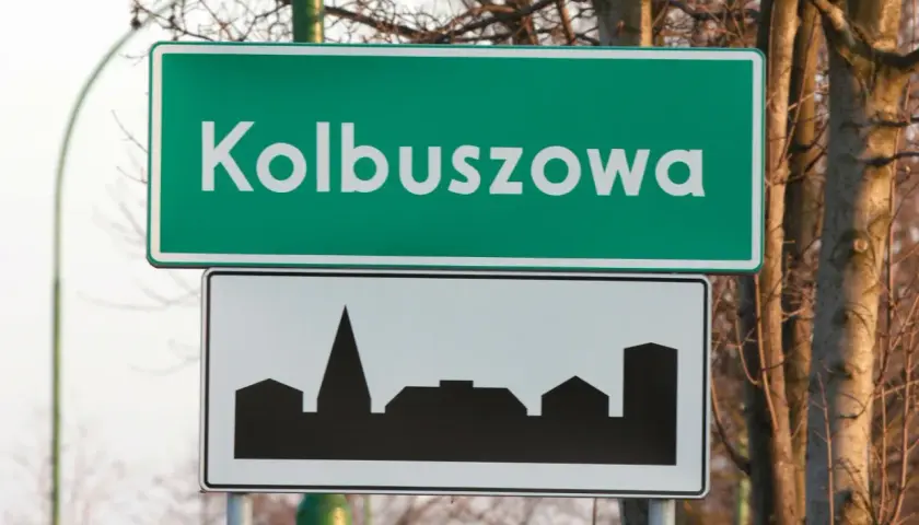Znak drogowy Kolbuszowa z sylwetką zabudowy miejskiej. Wjazd do miasta.