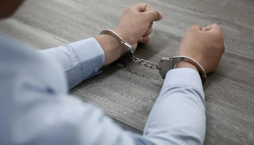 Ręce w kajdankach, być może schwytany członek gangu.