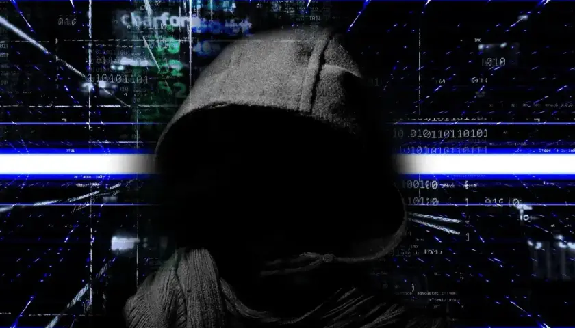 Sylwetka w kapturze na tle kodu binarnego i niebieskich linii. To wizualizacja tego, co można robić po kryminalistyce cyfrowej: analizować dane, ścigać cyberprzestępców.