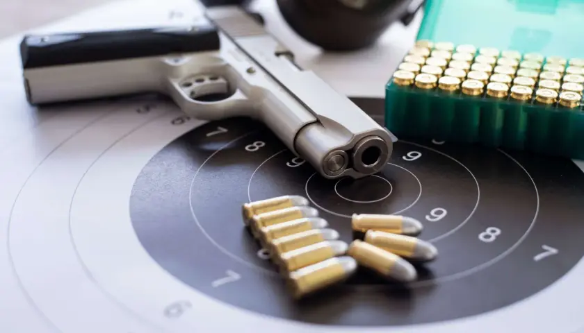 Pistolet, amunicja i tarcza strzelnicza. Wszystko gotowe do treningu, który może być częścią starań o pozwolenie na broń.