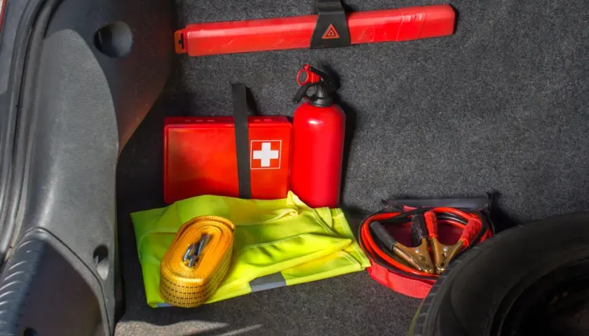 Czy apteczka jest obowiązkowa w samochodzie? W bagażniku widać apteczkę, gaśnicę, trójkąt, kamizelkę odblaskową i kable rozruchowe.