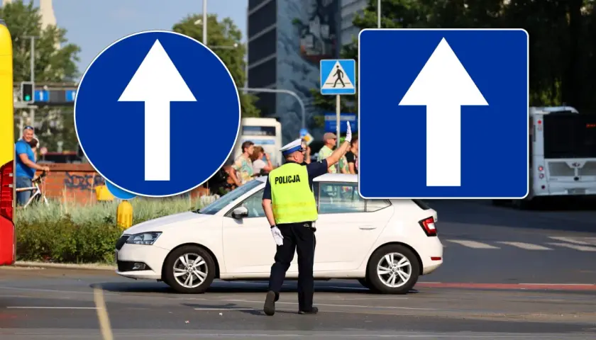 Policjant kieruje ruchem przy znakach "droga jednokierunkowa". Biała strzałka na niebieskim tle informuje o kierunku jazdy.