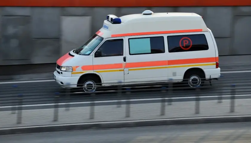 Ambulans z niebieskimi sygnałami świetlnymi, jadący na kursie pojazdy uprzywilejowane.