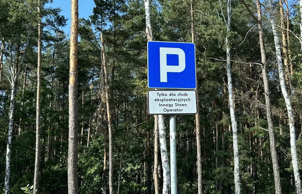 Znak D18 informuje o parkingu tylko dla służb eksploatacyjnych Innogy Stoen Operator. Otoczenie to gęsty las.