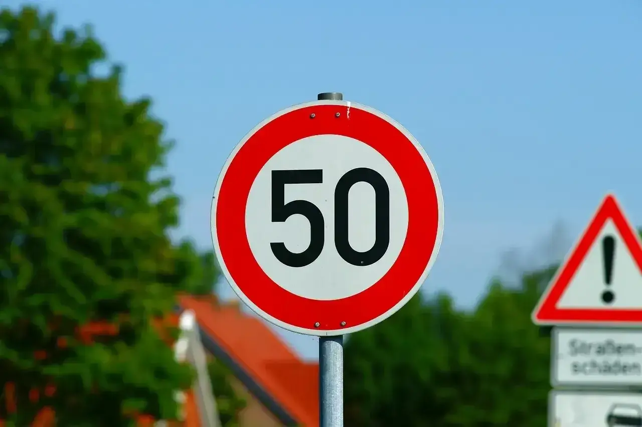 Znak ograniczenia prędkości do 50 km/h. Uważaj, przekroczenie prędkości o 50 km/h może być niebezpieczne.