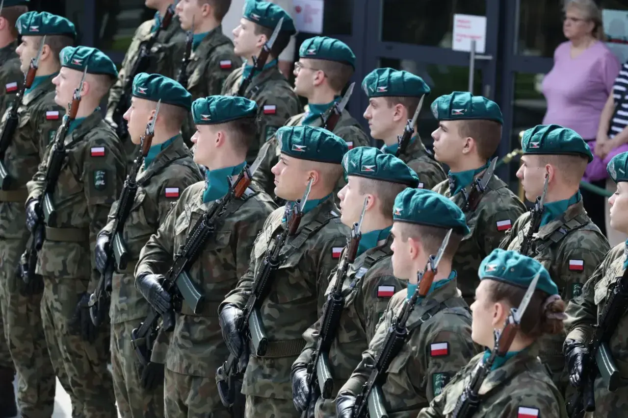 Żołnierze w zielonych beretach i mundurach stoją na baczność z karabinami. Zastanawiasz się, ile zarabia kapral w wojsku?