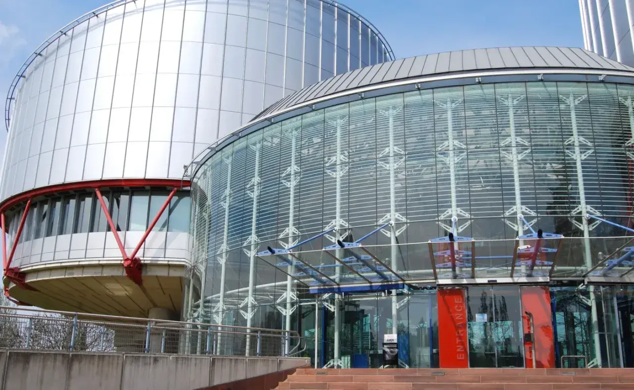 Nowoczesny budynek z przeszklonym wejściem i metalową fasadą. Tu zapadają ważne decyzje, tworząc precedens dla przyszłych pokoleń.