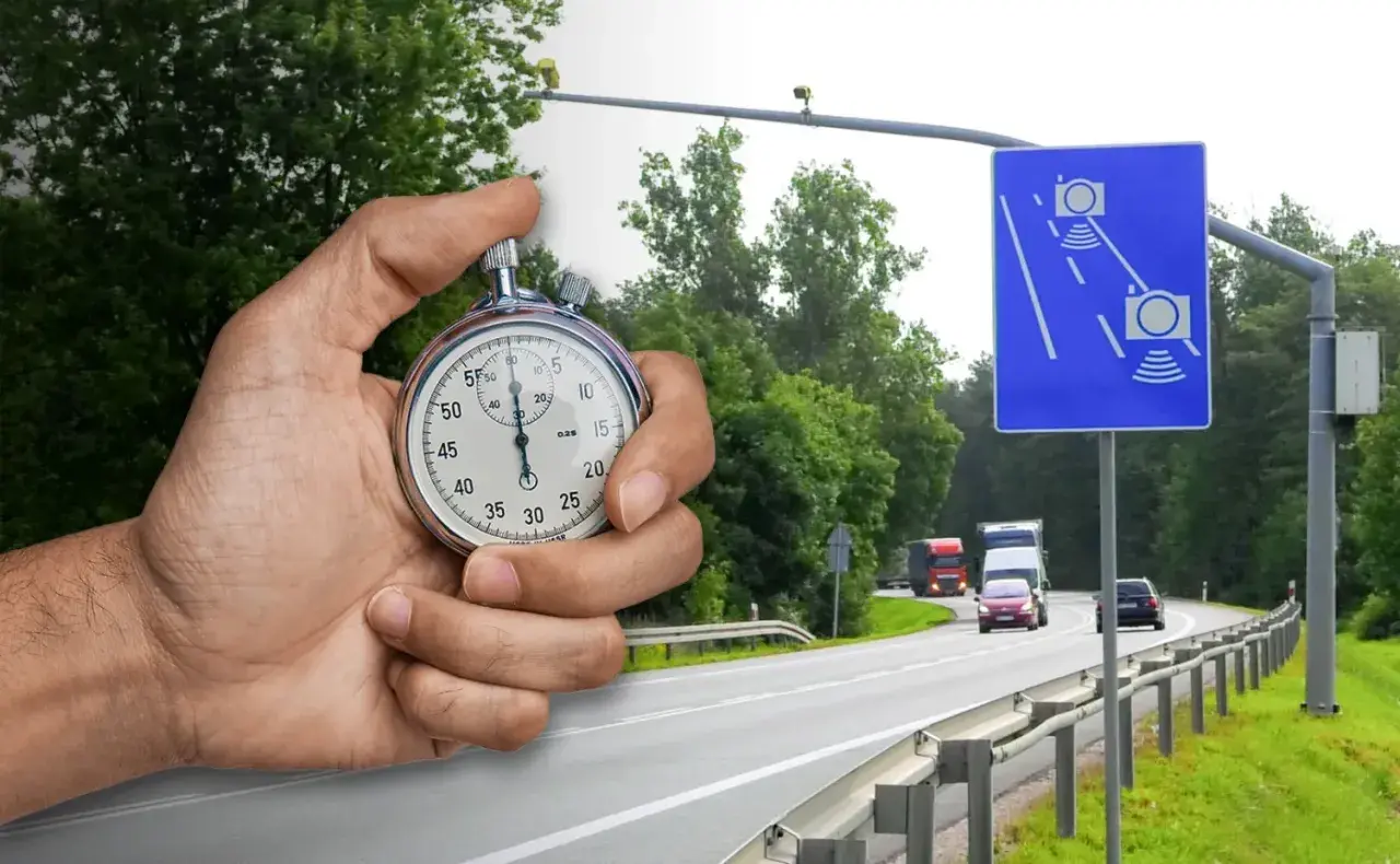 Dłoń trzyma stoper obok drogi z fotoradarem i znakiem informującym o kontroli prędkości. Czas ucieka, uważaj na ograniczenia!