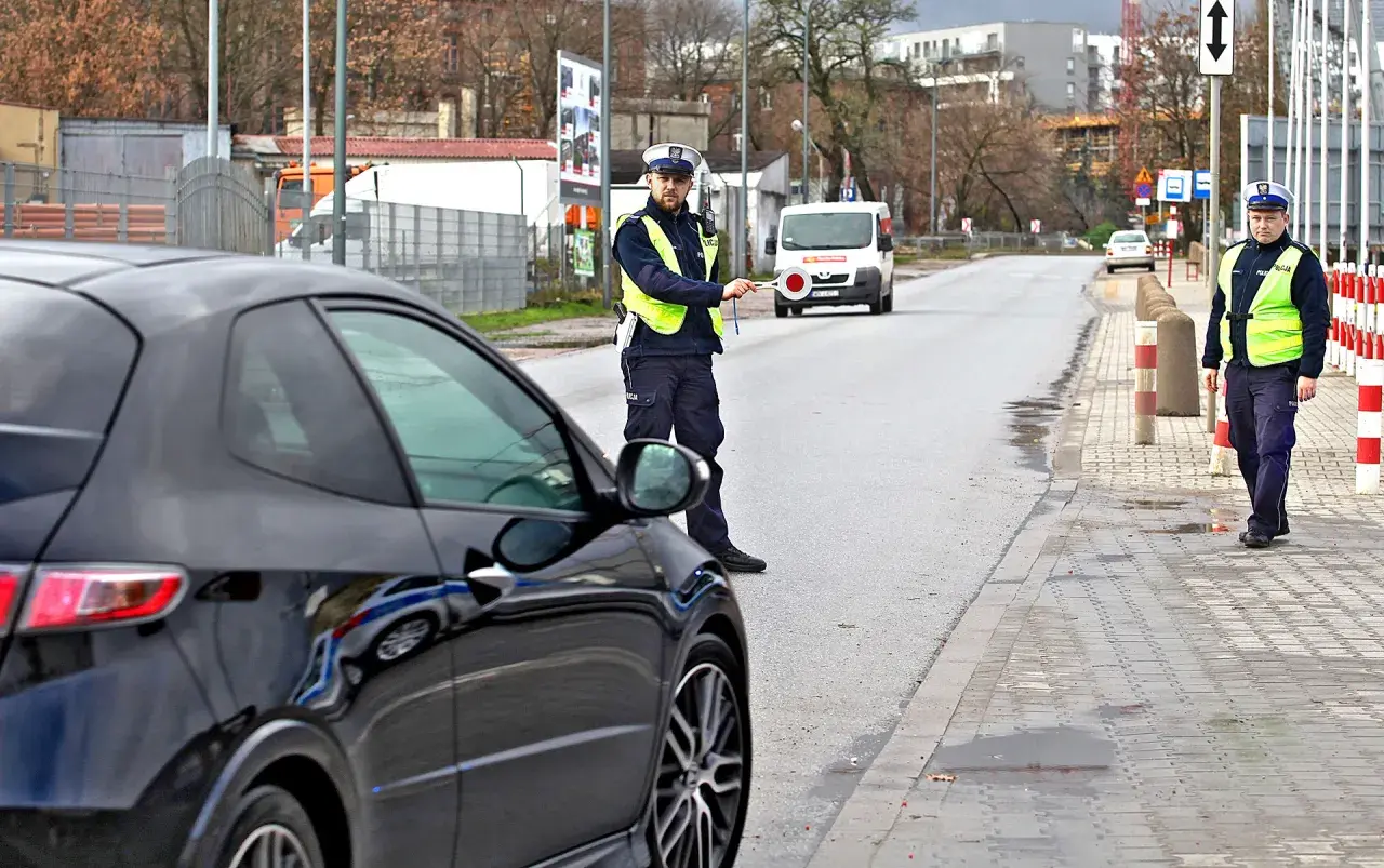Policjant zatrzymuje czarne auto. Czyżby to recydywa mandat za prędkość?