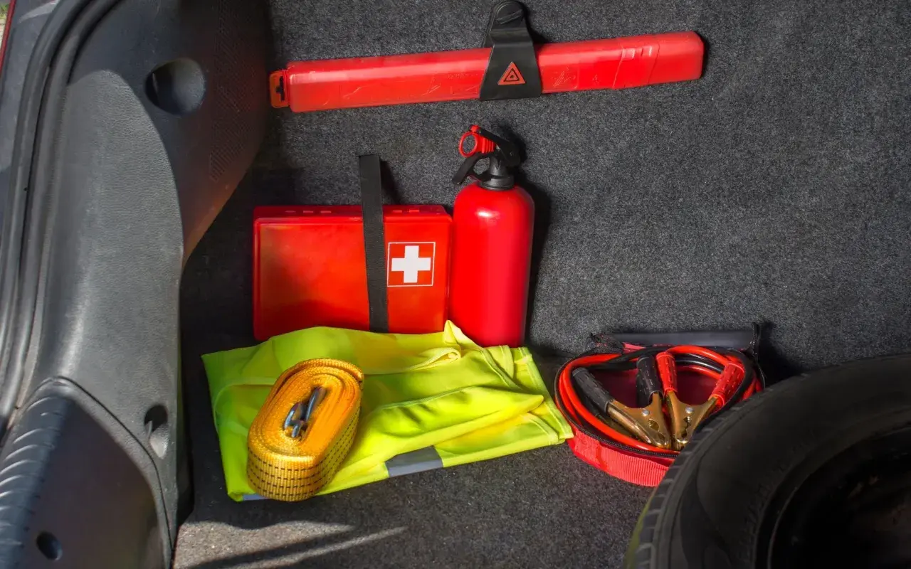 Czy apteczka jest obowiązkowa w samochodzie? W bagażniku widać apteczkę, gaśnicę, trójkąt, kamizelkę odblaskową i kable rozruchowe.