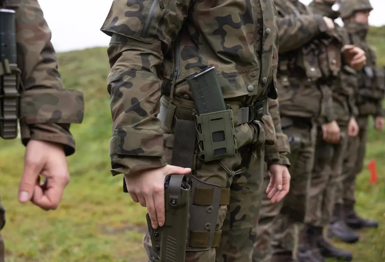 Żołnierze w mundurach polowych, gotowi do służby. Wiek poborowy w Polsce to czas przygotowania do obrony kraju.