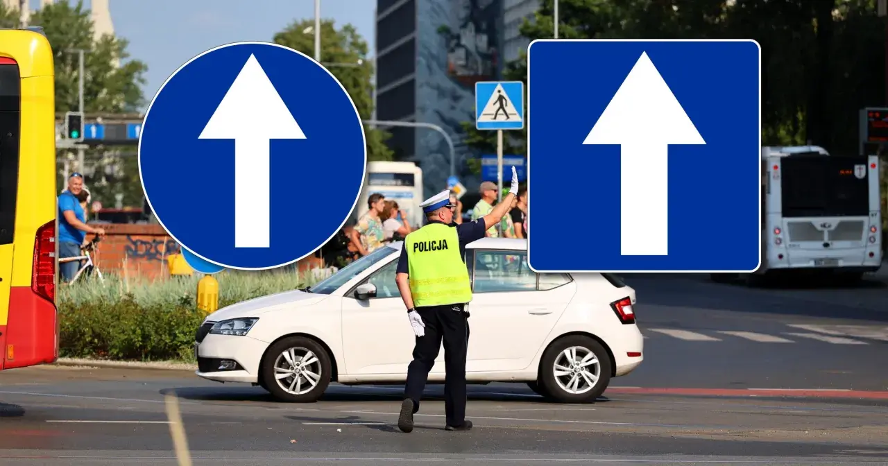 Policjant kieruje ruchem przy znakach "droga jednokierunkowa". Biała strzałka na niebieskim tle informuje o kierunku jazdy.