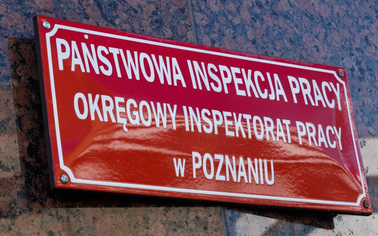 Tablica Państwowej Inspekcji Pracy w Poznaniu. To tutaj nadzór i kontrolę nad przestrzeganiem prawa pracy sprawuje instytucja dbająca o bezpieczeństwo pracowników.