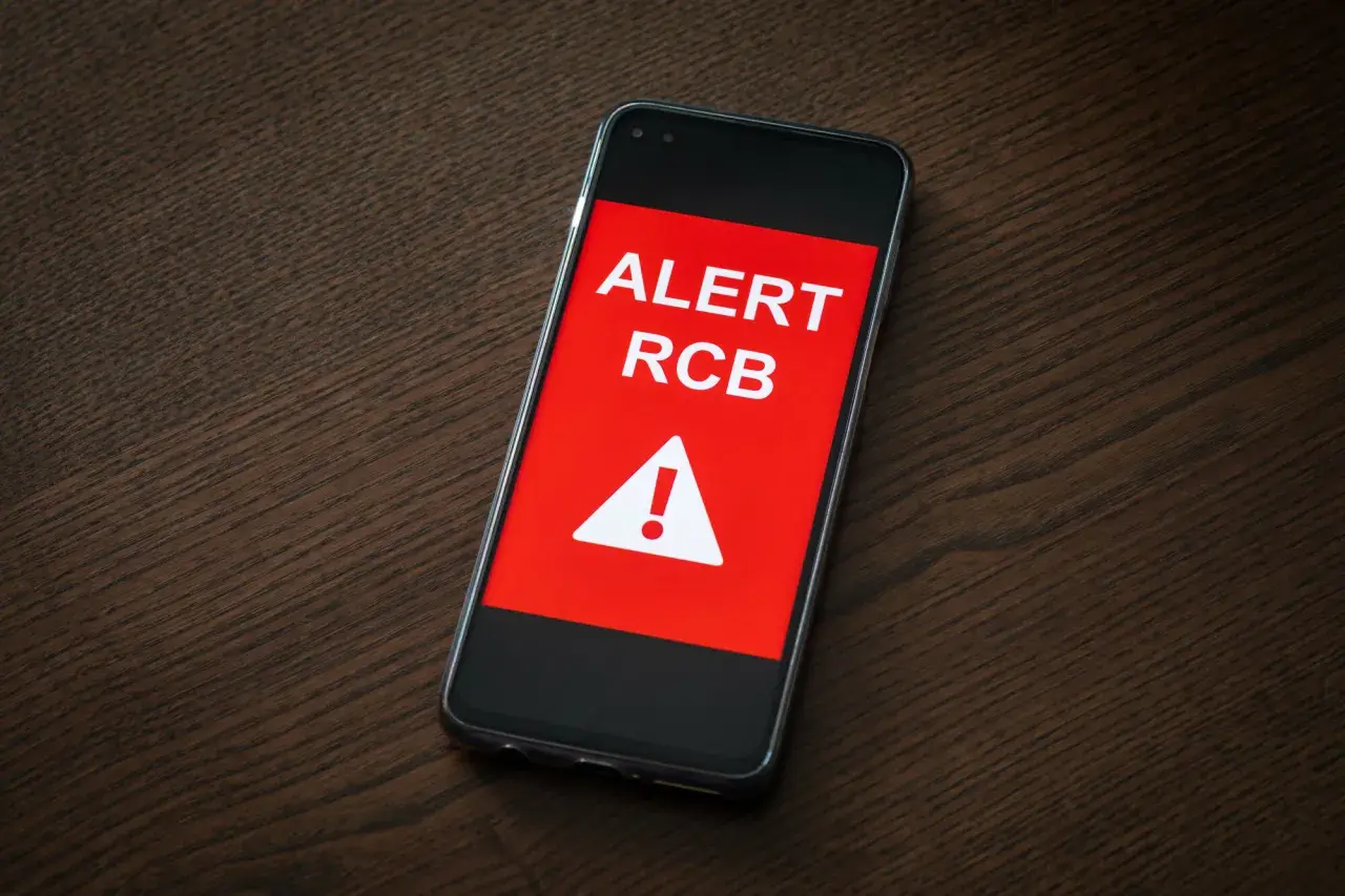 Telefon wyświetla komunikat "ALERT RCB" i symbol ostrzeżenia. To sygnał, że podniesiono stopnie alarmowe.