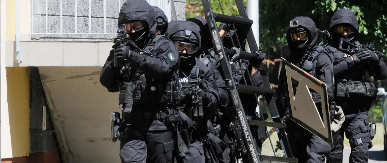 Grupa antyterrorystyczna w pełnym rynsztunku, gotowa do akcji przeciwko terroryzmowi. W rękach broń, na plecach sprzęt, a przed nimi nieznane zagrożenie.