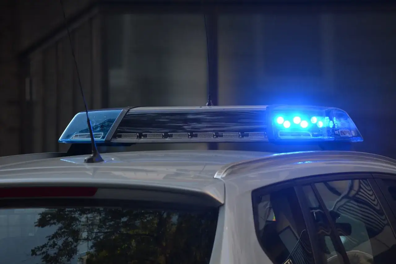 Niebieskie światła policyjne na dachu radiowozu. Chcesz wiedzieć, jak anonimowo zgłosić na policję?