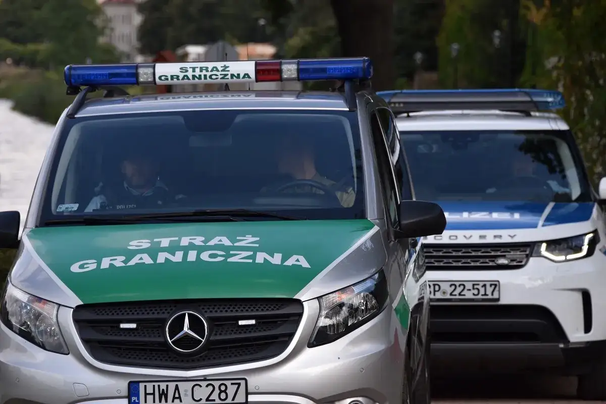 Samochody Straży Granicznej z włączonymi sygnałami świetlnymi, gotowe do kontroli na granicy niemieckiej.