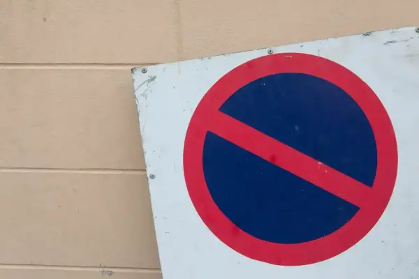 Znak b35 zakazu zatrzymywania się. Czerwone koło z czerwoną przekątną na niebieskim tle.